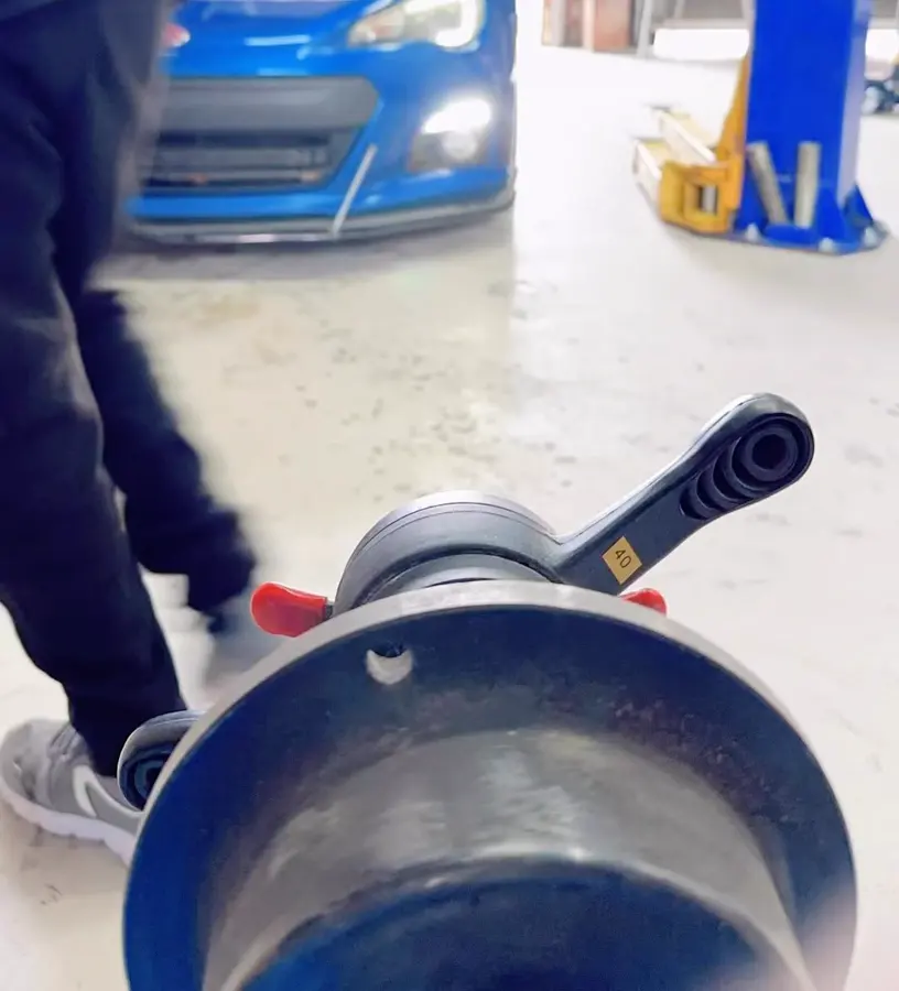 Wheel balancer at GN Tire & Lube with a blue sports car pulling into the bay